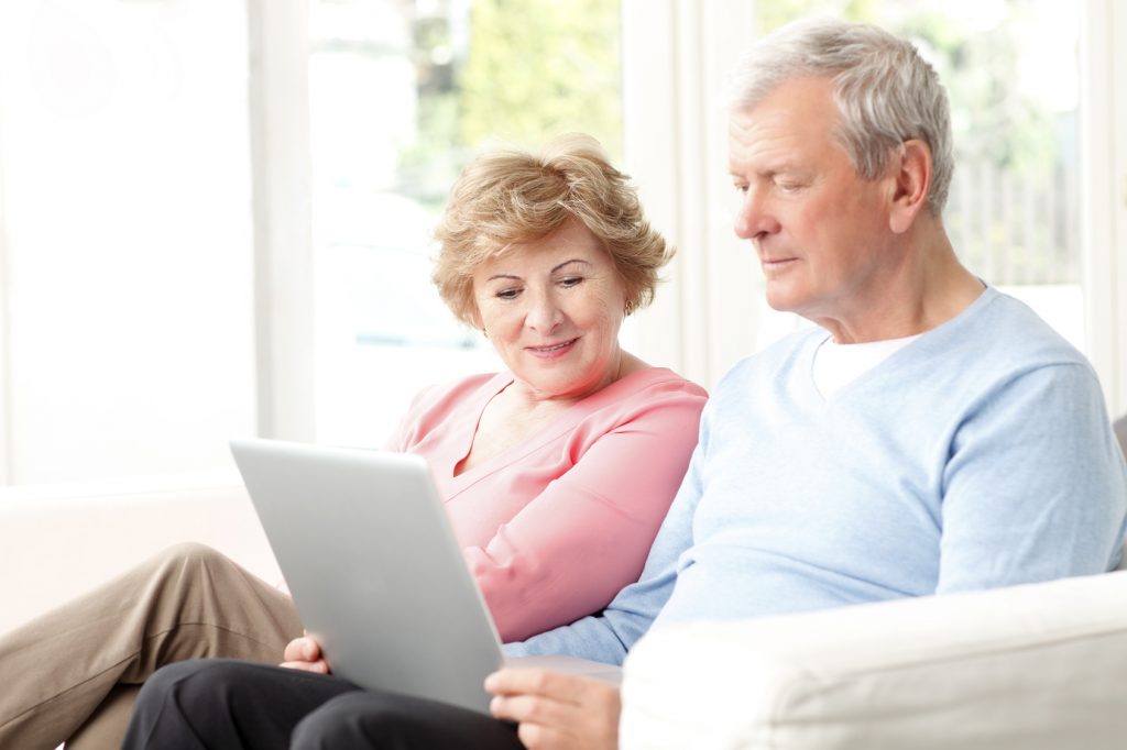 Portrait of active senior couple surfing on internet.